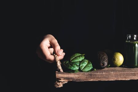 Girl holds a smoothie with spinach, avocado and lime on a vintage tray. Wholesome food, vegan, eco.の写真素材