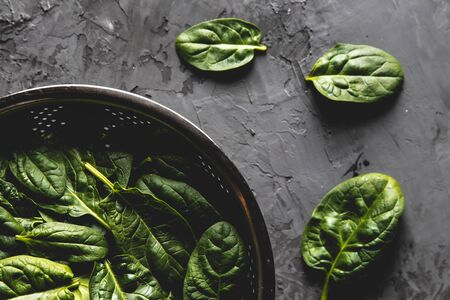 Fresh mini spinach in a colander on the old concrete table. Healthy food, eco product. Veganの写真素材