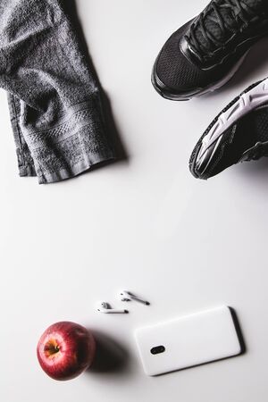 Mockup mobile cellphone with earphone and running shoes on white background. Healthy active lifestyles background concept. Daily workout and relax music lifestyles .の写真素材