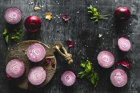 Red Onion Slices on wooden board with dark backgroundの写真素材