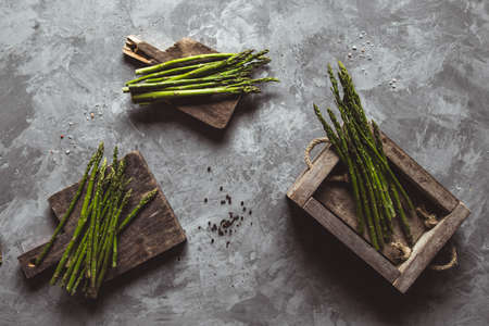 Asparagus on a cutting board in a wooden box. Healthy food, health on a concrete background.の写真素材