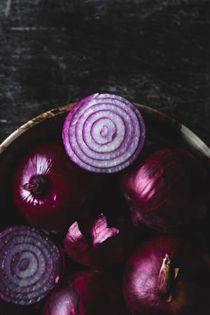 Plate with purple onion. Onions with water droplets. On the table scattered onion husk. Breakfast for a vegetarianの写真素材