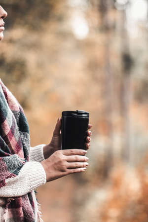 Woman hold cup in forest, autumn photograph