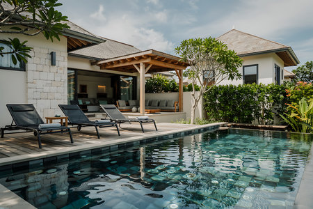 This image showcases a luxurious villa with a stunning private swimming pool and an inviting outdoor living area The serene ambiance is perfect for a relaxing vacation getaway in a tropical paradise The contemporary design of the villa features comfortable lounge chairs a shaded pavilion and lush greenery The crystalclear water of the pool reflects the architecture and sky creating a tranquil scene The villa interior is visible providing comfortable living space This is a perfect setting for a highend travel or real estate promotionの素材