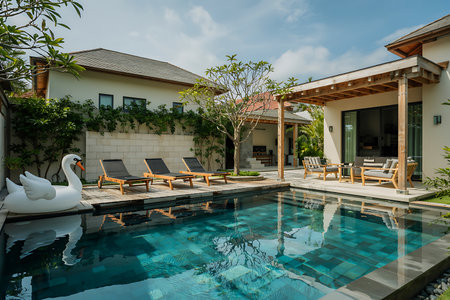 Swimming pool with sun loungers and umbrellas in luxury villaの素材