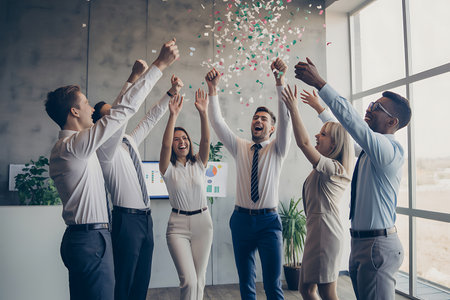 Group of business people celebrating success with confetti in modern office.の素材