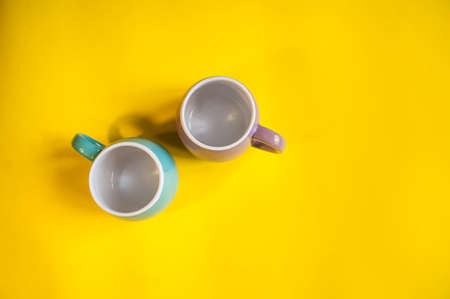 Bright yellow background two cupsの写真素材