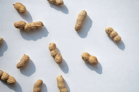 unpeeled peanuts on a white background