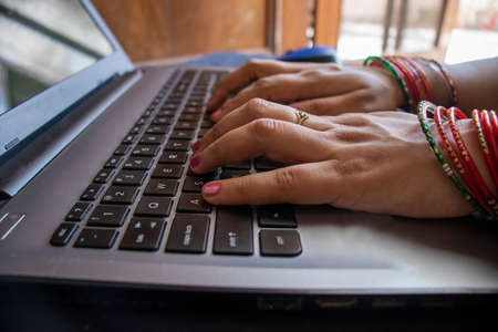indian Female wearing bangles and working form home.