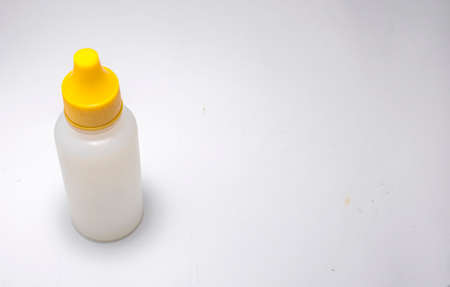 White bottle with yellow cap isolated on white