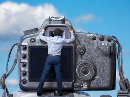 Giant camera and small photographer. Surreal concept