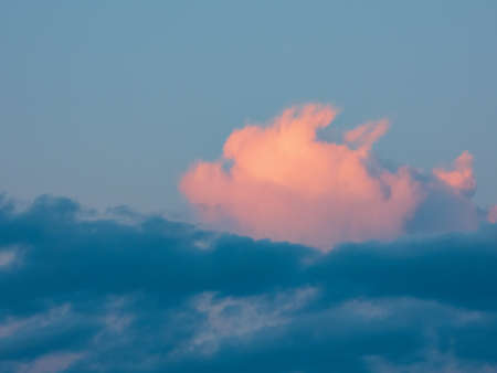 The sky at dawn. Part of the clouds are colored pink by the rising sunの写真素材