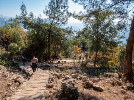 Tourists descend on a wooden deck in the ancient city of Syedra, located on the slope of the Taurus Mountains, Mediterranean coast, South Turkey, on a sunny dayの写真素材