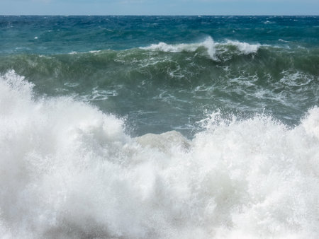 Large waves breaking on shore in Mediterranean sea, storm on a sunny dayの写真素材
