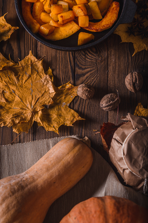 Pumpkin in a frying pan on a wooden table with walnutsの写真素材