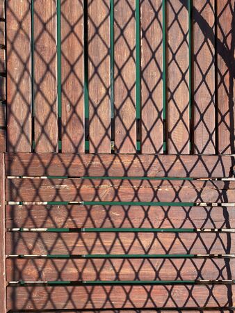 Wooden pier with chiaroscuro pattern. The play of light and shadow. view from above. Background. Texture.の写真素材