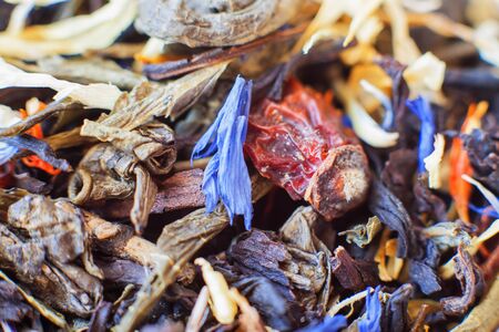 dried tea leaves with safflower additions, cornflower and rose hips in a glass jar. Tea welding. Macro photography.の写真素材