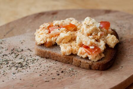 brown bread toast with scramble omelet with tomatoes and cheese. Sprinkled with oregano. traditional breakfastの写真素材