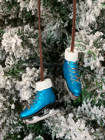 Christmas toy on a snow-covered artificial tree. Christmas toy blue skates on a snowy tree. Christmas decoration. happy New Year.の写真素材