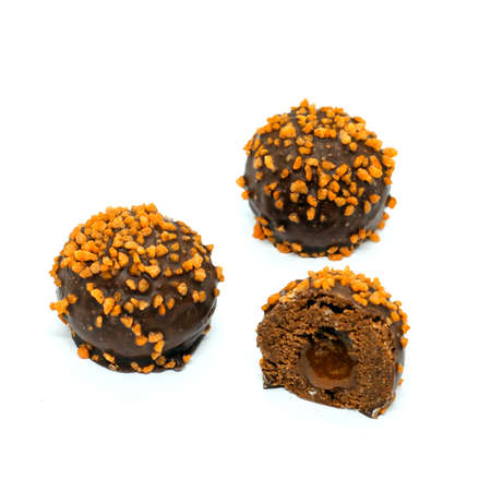 chocolate-orange petit-four cakes with caramel-orange liquid filling isolated on white background. chocolates with liquid filling.の写真素材