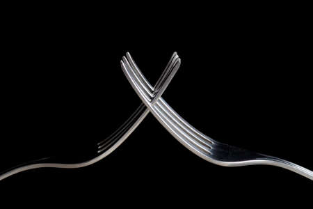 Old forks crossed on black backgroundの写真素材
