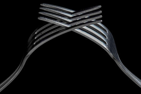 Old crossed forks on black backgroundの写真素材