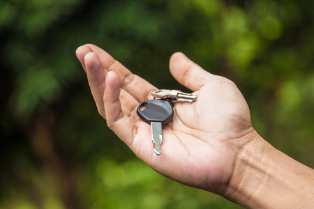 Hand holding motorcycle car keyの写真素材