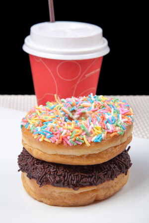 Stack of Donuts and coffee in white plate with black backgroundの写真素材