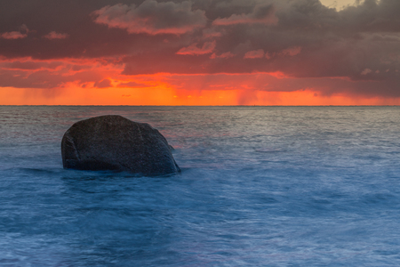 Dramatic clouds with a red horizon to the sunrise at the Baltic Sea.の写真素材