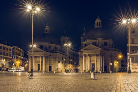 Piazza del Popolo or Peoples Square with twin churches Santa Maria di Monte Santo, Santa Maria dei Miracoli and Obelisk is one of the most famous squares in Rome heading south at night and lightingの写真素材