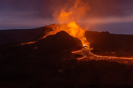 View of volcanic eruption in Iceland. Crater from the volcano Fagradalsfjall at night to the blue sky with liquid lava. Volcano on the Reykjanes peninsula in the GeoParkの写真素材