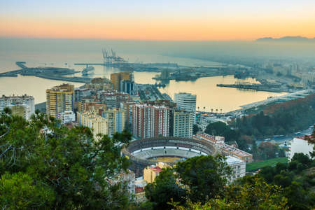 Panorama of the center of the city of Malaga. Sunset with blue sky on the Spanish Costa del Sol coastline of the city, port, houses, trees and bullringの写真素材