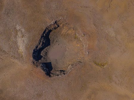 inactive volcanic crater from above. Drone view of landscape in Iceland of Reykjanes Peninsula. Path to the old crater on brown sand surface around the crater with shadows when theの写真素材