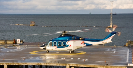 A photo of passenger helicopter waiting to take off from the platform behind fountainsのeditorial素材