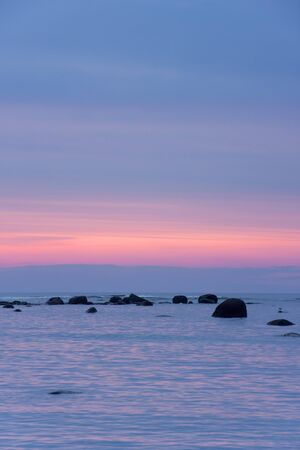 Sunset at sea  Stones in water の写真素材