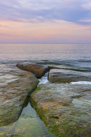 Rocks in water at sunsetの写真素材