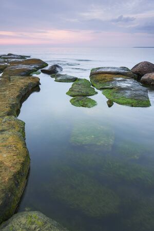 Stones in water at sunset  Rocks are visible under water also の写真素材