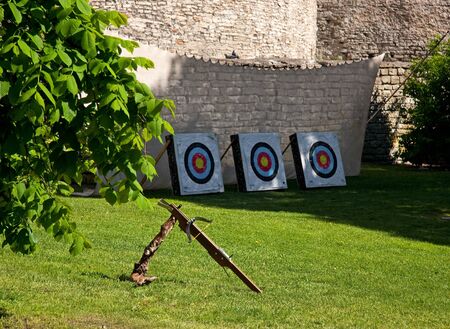 Crossbow and three colorful targets in front of a big curtain wall of the Old Town of Tallinn, Estonia の写真素材