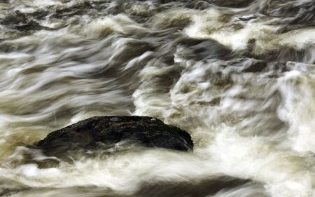 Rock in flowing riverの写真素材