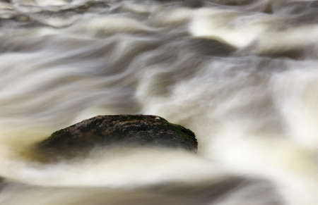 Rock in flowing riverの写真素材