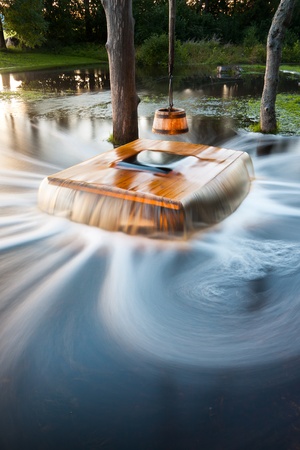 Old flooding well and a sweep or shadoof with timber bucket at golden sunlight. The name of the well is NÃµiakaev (Witch's well)の写真素材