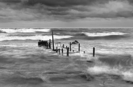 Wooden bridge in a stormy and wavy seaの写真素材