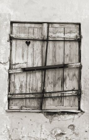 Old wood made window hatch or shutter with heart shape in itの写真素材