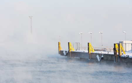 Misty sea and yellow shipping docks at portの写真素材