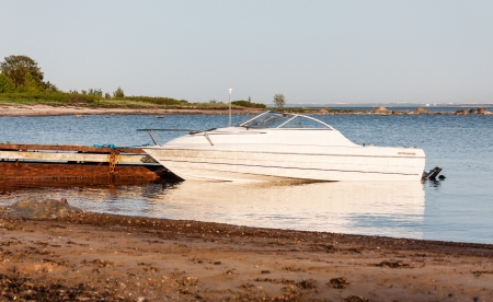 White motor boat parking aside rusty quayの写真素材