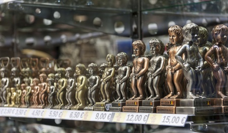 Sculpture of a peeing boy on a showcase at shop windowの写真素材