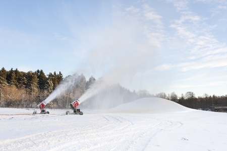 Snow blowing machines or snow cannons making snowの写真素材