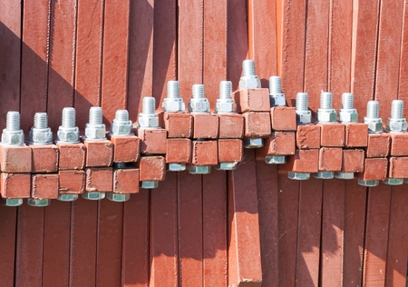 Red objects tied together with bold bolts 
