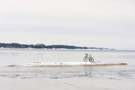 Bicycle on a small island in sea at winterの写真素材