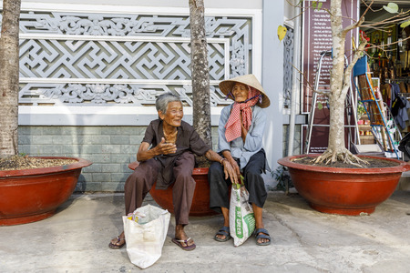 MY THO, VIETNAM - FEBRUARY 24, 2018: Old Vietnamese women sit on a bench in My Tho, Vietnamのeditorial素材
